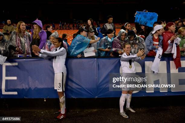 French defender Wendie Renard and French midfielder Amandine Henry take photos with fans after the She Believes Cup US vs. France match at RFK...