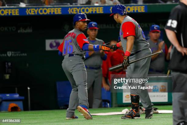 Yoelqui Cespedes of Team Cuba is greeted by teammate Frederich Cepeda after scoring a run in third inning during the Game 1 of Pool B against Team...