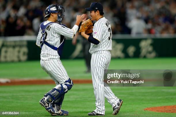 Kazuhisa Makita and Seiji Kobayashi of Team Japan celebrate after winning the Game 1 of Pool B against Team Cuba at the Tokyo Dome on Tuesday, March...