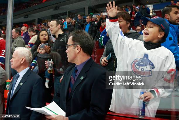 Fan cheers as Canucks assistant coaches Doug Jarvis and Doug Lidster during their NHL game against the Montreal Canadiens at Rogers Arena March 7,...