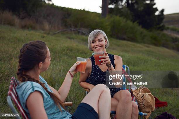 two women toasting on camping trip - drinking juice stock-fotos und bilder