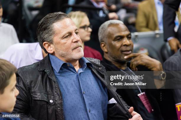 Cleveland Cavaliers owner Dan Gilbert sits next to former NBA player Charles Oakley prior to the game between the Cleveland Cavaliers and the New...