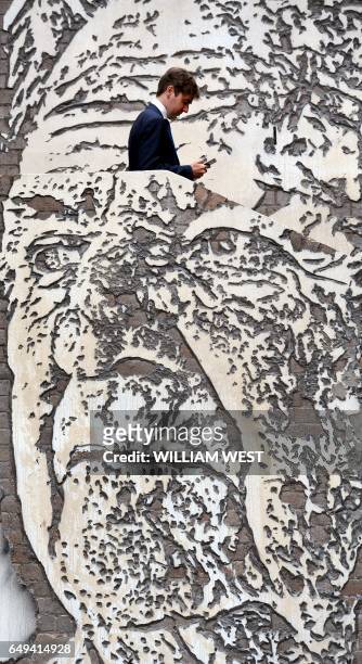 Man walks up a staircase adorned with a mural by artist Alexandre Farto of Jack Mundey in the Rocks district of Sydney on March 2017. Mundey was a...