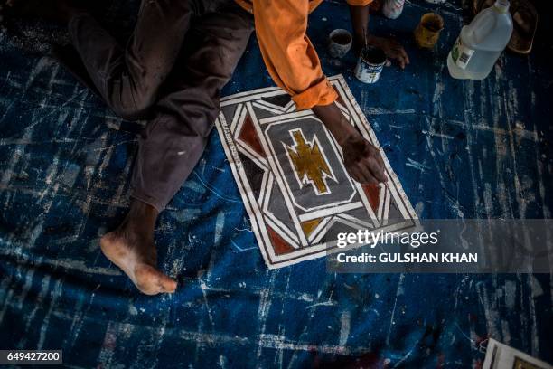 Student of South African artist Esther Mahlangu paints a design in her home in Mabhoko Village, Siyabuswa, Mpumalanga on March 6, 2017. Mahlangu...