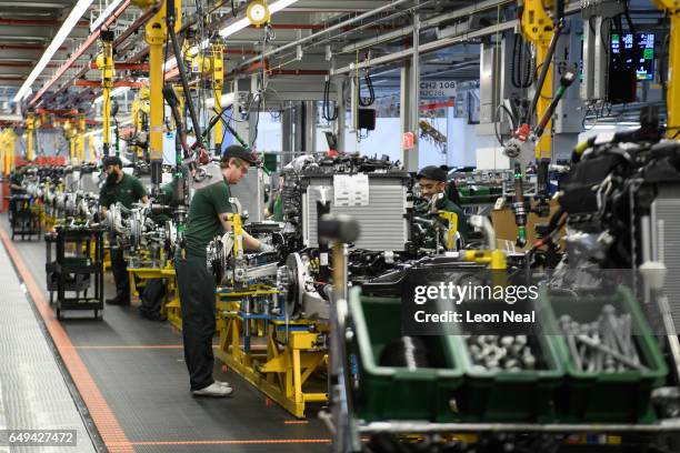 Workers assemble parts of the chassis during an early stage of production at the Jaguar Land Rover factory on March 1, 2017 in Solihull, England. The...