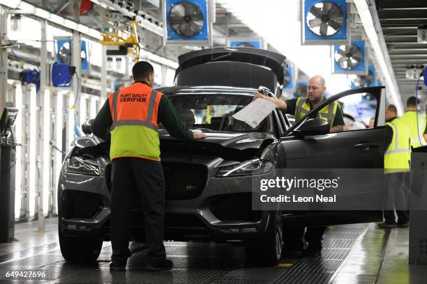 Vehicles are checked before moving to the next stage of production at the Jaguar Land Rover factory on March 1, 2017 in Solihull, England. The...