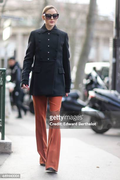 Olivia Palermo wears a black military jacket, and orange pants, outside the Miu Miu show, during Paris Fashion Week Womenswear Fall/Winter 2017/2018,...