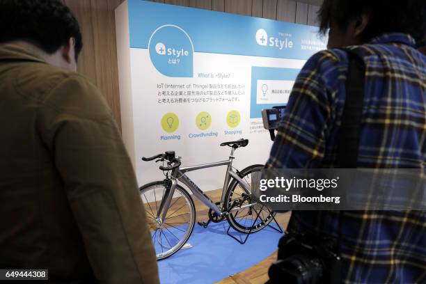 Attendees look at a CycleLabs Solutions Inc. SmartHalo smart biking device attached to the handlebars of a bicycle at a SoftBank Corp. +Style media...