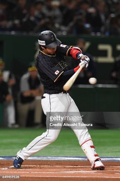 Designated hitter Tetsuto Yamada of Japan hits a single in the top of the first inning during the World Baseball Classic Pool B Game Three between...