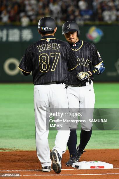 Infielder Ryosuke Kikuchi of Japan high fives with coach Toshihisa Nishi after hits a single in the top of the first inning during the World Baseball...