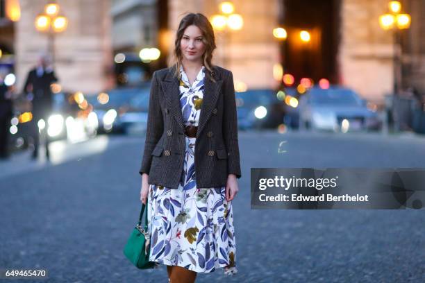 Angelica Ardasheva wears a blazer jacket, a flower print dress, brown suede boots, and a green bag, outside the Louis Vuitton show, during Paris...