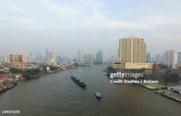 Aerial drone view of a tug boat and barge on the Chao Phraya river in Bangkok. .