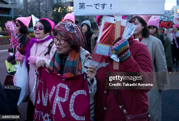 Participants hold signs and shout slogans during the Women's March Tokyo on March 8, 2017 in Tokyo, Japan. March 8, 2017 marks the the International...