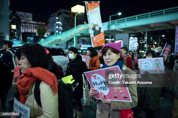 Participants hold signs and shout slogans during the Women's March Tokyo on March 8, 2017 in Tokyo, Japan. March 8, 2017 marks the the International...