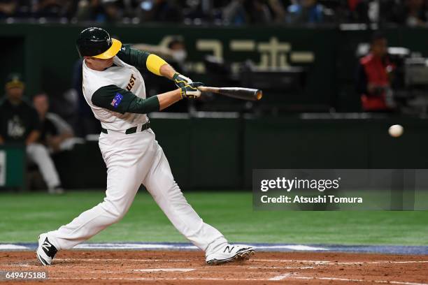 Infielder Luke Hughes of Australia hits a single in the bottom of the fourth inning during the World Baseball Classic Pool B Game Three between Japan...