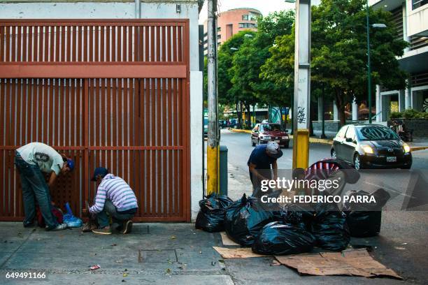 People scavenge for food in the streets of Caracas on February 22, 2017. Venezuelan President Nicolas Maduro is resisting opposition efforts to hold...