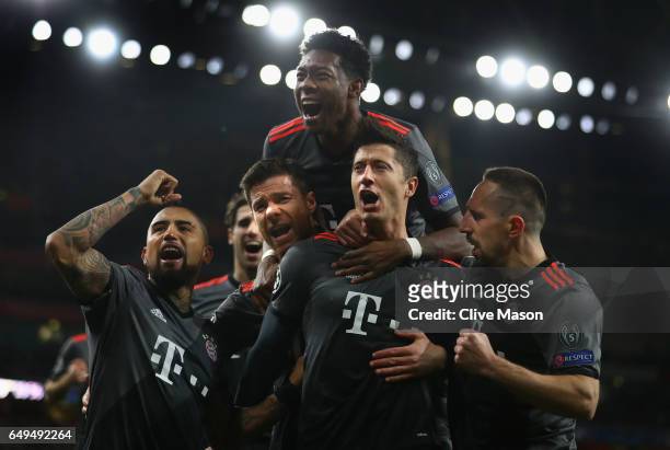 Robert Lewandowski of Bayern Muenchen celebrates with team mates as he scores their first goal from a penalty during the UEFA Champions League Round...