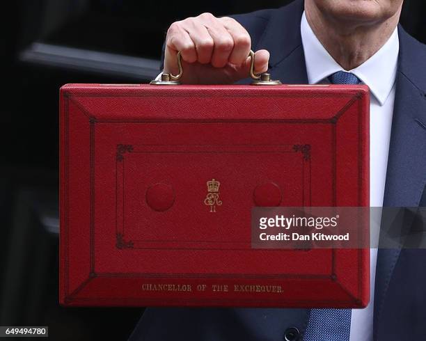 Chancellor of the Exchequer Philip Hammond holds the budget box up to the media as he leaves 11 Downing Street on March 8, 2017 in London, England....