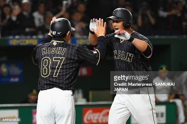 Infielder Sho Nakata of Japan celebrates with coach Toshihisa Nishi after hitting a solo homer in the top of the seventh inning during the World...