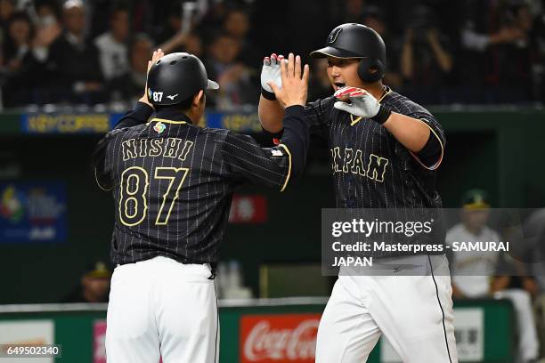 Infielder Sho Nakata of Japan celebrates with coach Toshihisa Nishi after hitting a solo homer in the top of the seventh inning during the World...