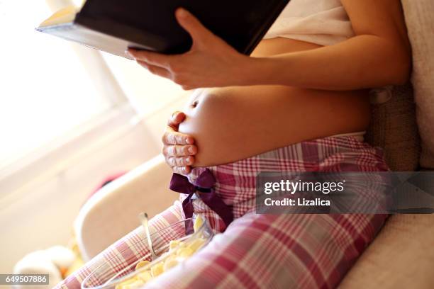 schwangere frau buch für ihr baby - holprig stock-fotos und bilder
