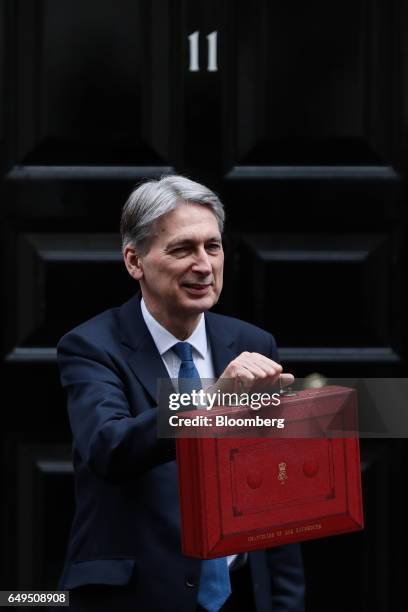 Philip Hammond, U.K. Chancellor of the exchequer, poses for photographers holding the dispatch box containing the budget, as he exits 11 Downing...