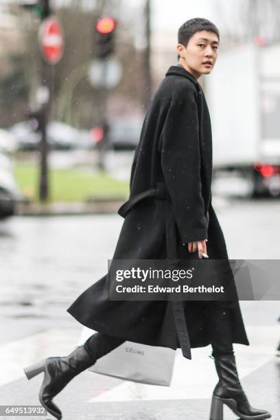 Model wears a black coat, and black boots, outside the Celine show, during Paris Fashion Week Womenswear Fall/Winter 2017/2018, on March 5, 2017 in...