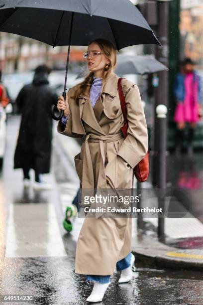 Guest wears a trench coat, outside the Celine show, during Paris Fashion Week Womenswear Fall/Winter 2017/2018, on March 5, 2017 in Paris, France.