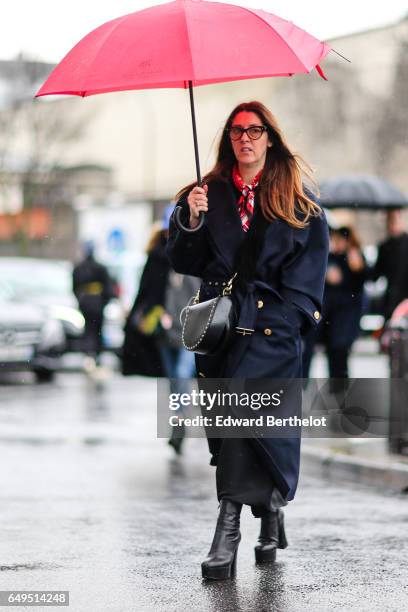 Guest wears a blue coat, and a red umbrella, outside the Celine show, during Paris Fashion Week Womenswear Fall/Winter 2017/2018, on March 5, 2017 in...