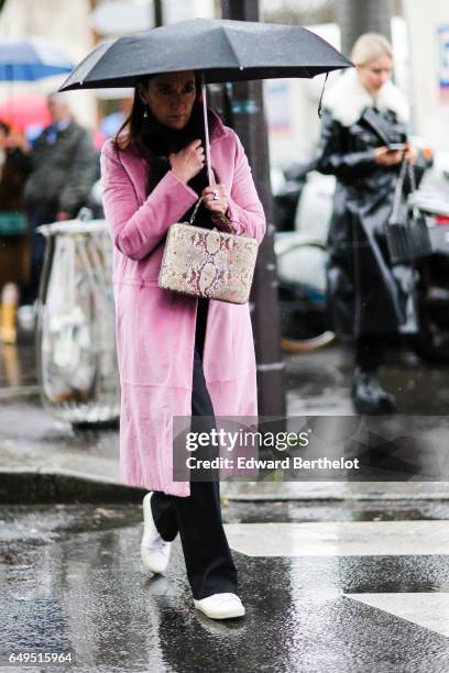 Guest wears a pink coat and black pants, outside the Celine show, during Paris Fashion Week Womenswear Fall/Winter 2017/2018, on March 5, 2017 in...