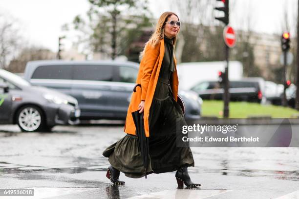 Guest wears an orange coat and a green dress, outside the Celine show, during Paris Fashion Week Womenswear Fall/Winter 2017/2018, on March 5, 2017...