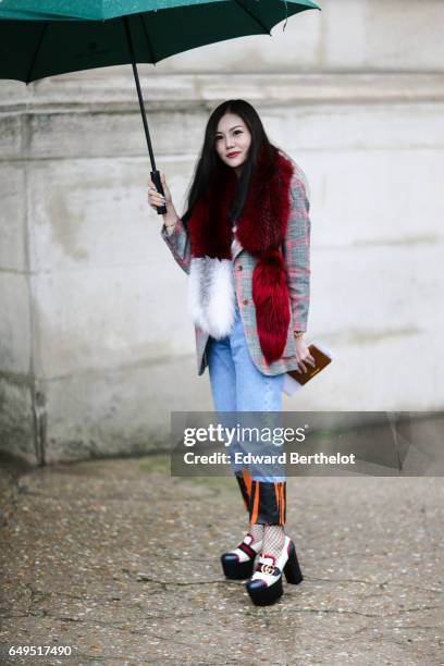 Guest wears Gucci shoes, blue jeans, and a red fur scarf, outside the Elie Saab show, during Paris Fashion Week Womenswear Fall/Winter 2017/2018, on...