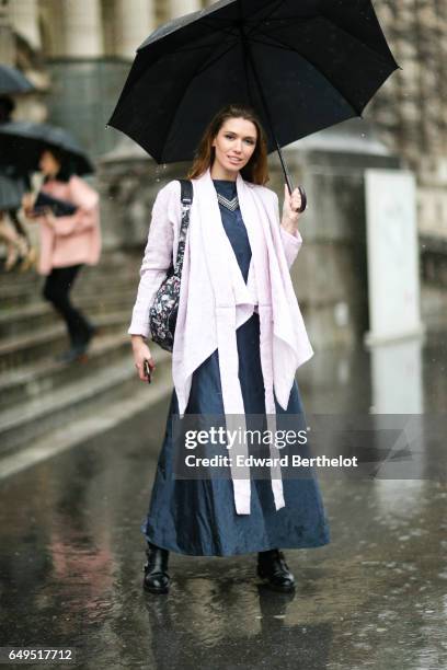 Guest wears a dress, and an umbrella, outside the Elie Saab show, during Paris Fashion Week Womenswear Fall/Winter 2017/2018, on March 4, 2017 in...