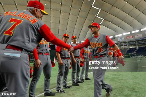 Joey Wong and manager John McLaren of Team China shake hands during player introductions prior to Game 2 of Pool B against Team Cuba at the Tokyo...