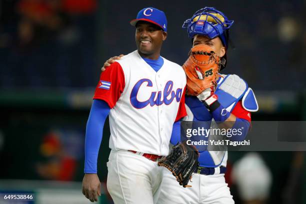 Bladimir Banos and Frank Morejon of Team Cuba smile as they walk back to the dugout during Game 2 of Pool B against Team China at the Tokyo Dome on...