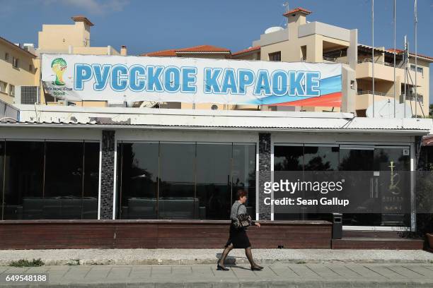 Woman walks past a Russian karaoke bar on March 8, 2017 in Limassol, Cyprus. Cyprus has largely recovered from its 2012-2013 economic crisis. The...