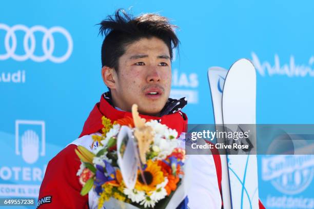 Gold medalist Ikuma Horishima of Japan poses during the flower ceremony for the Men's Moguls on day one of the FIS Freestyle Ski & Snowboard World...