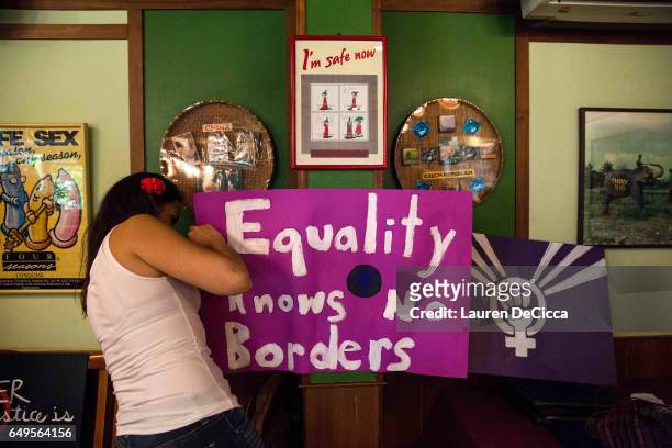 Angela Rojas, one of the organizers of the women's strike in Bangkok posts an "equality knows no borders" sign in the Cabbages and Condoms restaurant...
