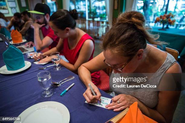 Women write their personal messages on index cards to be posted on the "I stand for" message board where women share why they strike on March 8, 2017...