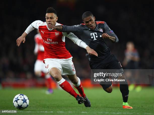 Douglas Costa of Bayern Muenchen and Francis Coquelin of Arsenal battle for the ball during the UEFA Champions League Round of 16 second leg match...