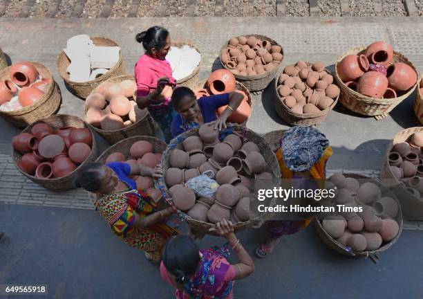 Women vendor wait at Mahim Station with earthen pots to sell on eve of International Women's Day, on March 7, 2017 in Mumbai, India. International...