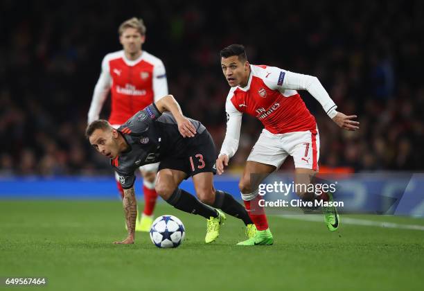 Alexis Sanchez of Arsenal evads a tackle by Rafinha of Bayern Muenchen during the UEFA Champions League Round of 16 second leg match between Arsenal...