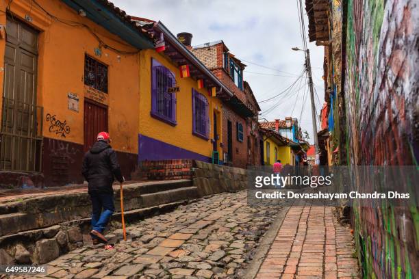 bogotá, colombia - los turistas en la carrera segunda colorida en el histórico barrio de la candelaria - calle del embudo fotografías e imágenes de stock