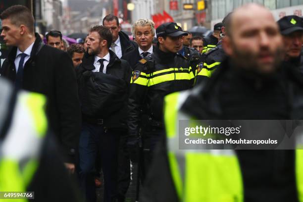 Candidate, Geert Wilders is guarded by police after he speaks to the crowd, hands out pamphlets or flyers and poses for selfies on his election...