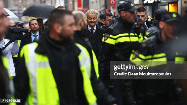 Candidate, Geert Wilders is guarded by police after he speaks to the crowd, hands out pamphlets or flyers and poses for selfies on his election...