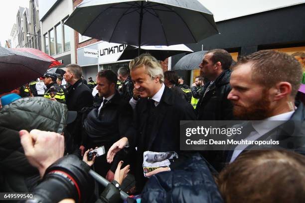 Candidate, Geert Wilders is guarded by police as he speaks to the crowd, hands out pamphlets or flyers and poses for selfies on his election campaign...