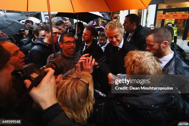 Candidate, Geert Wilders is guarded by police as he speaks to the crowd, hands out pamphlets or flyers and poses for selfies on his election campaign...