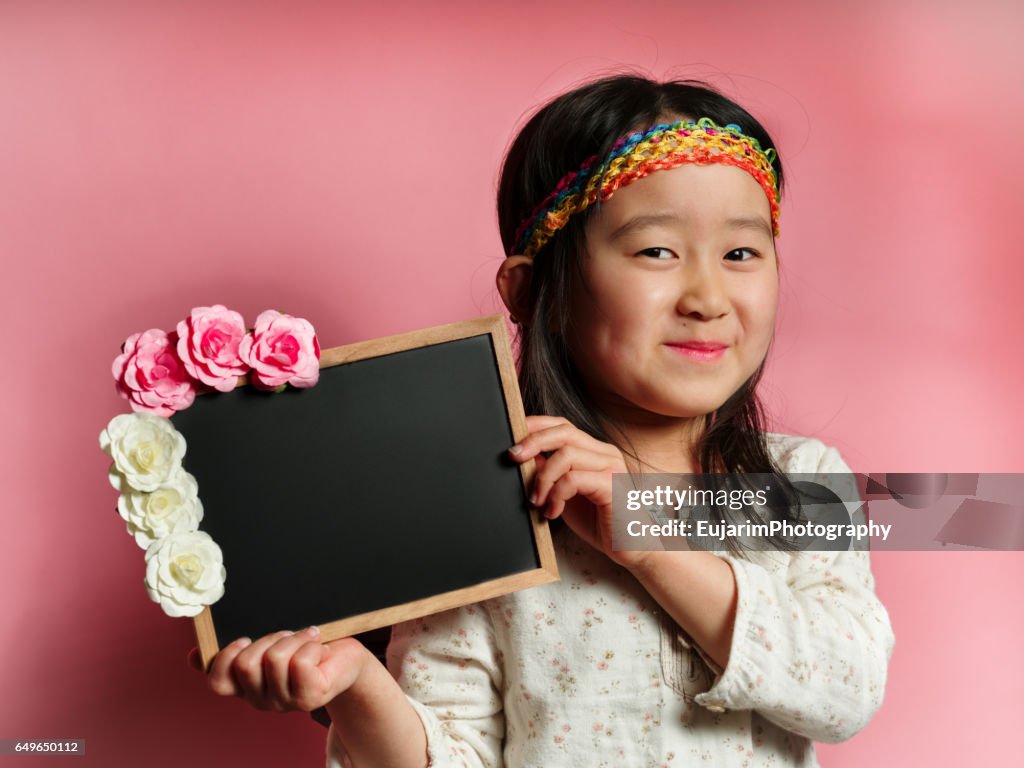 Gypsy hippie style cute girl, holding small blackboard
