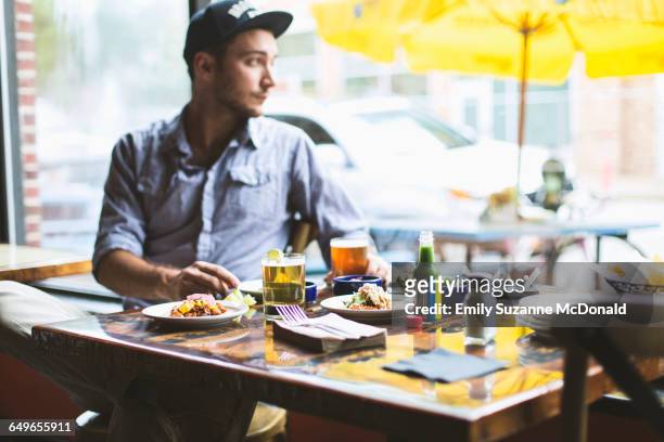 caucasian man eating tacos in restaurant - missouri mittlerer westen stock-fotos und bilder