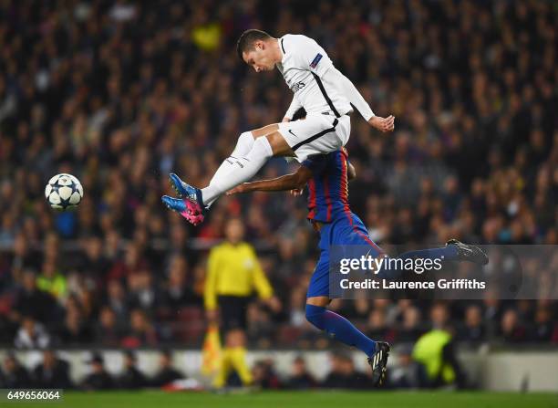 Julian Draxler of PSG jumps with Rafinha of Barcelona during the UEFA Champions League Round of 16 second leg match between FC Barcelona and Paris...